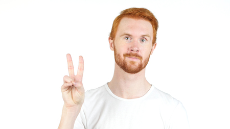 Young student red hair showing victory sign Isolated on white background.の写真素材