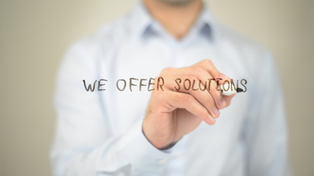We Offer Solutions,  Man writing on transparent screenの写真素材
