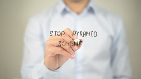 Stop Pyramid Scheme , man writing on transparent screenの写真素材
