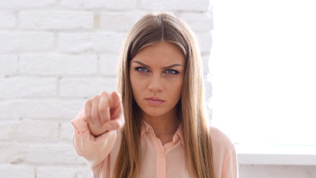 Serious Woman Pointing at Camera in Officeの写真素材