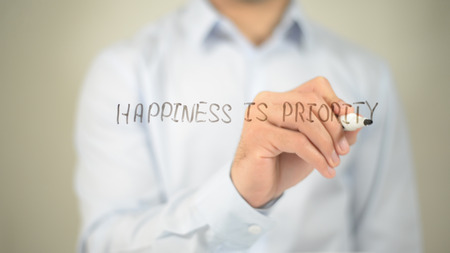 Happiness Is Priority , man writing on transparent screenの写真素材