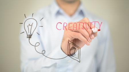 Creativity, Glowing Bulb Concept, Man writing on transparent screenの写真素材