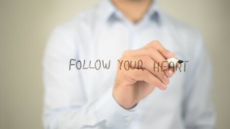 Follow Your Heart, man writing on transparent screenの写真素材