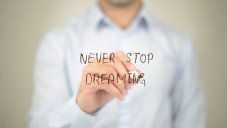 Never Stop Dreaming,  Man writing on transparent screenの写真素材