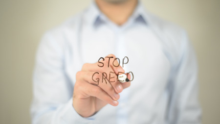 Stop Greed , man writing on transparent screenの写真素材