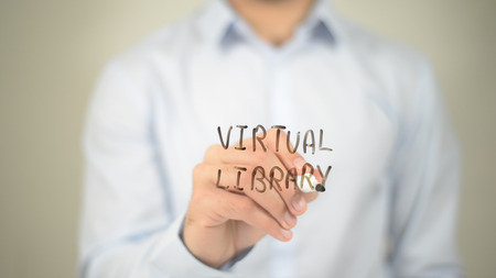 Virtual Library, man writing on transparent screenの写真素材