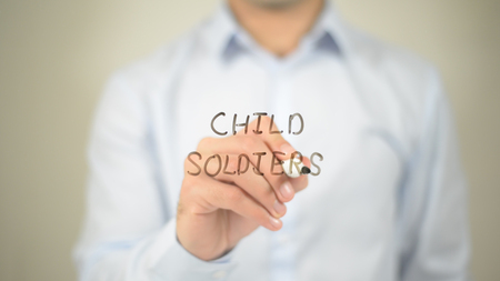 Child Soldiers, man writing on transparent screenの写真素材