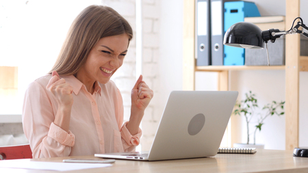 Creative Woman Celebrating Success at Workの写真素材