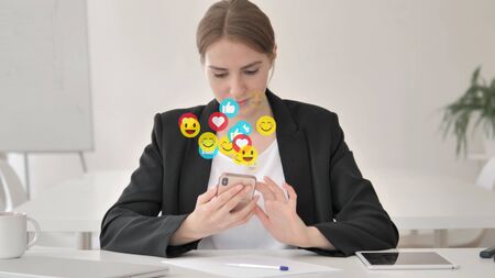 Young Businesswoman Using Smartphone, Comments, Emoji and Likesの写真素材