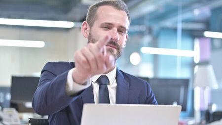 The Portrait of Cheerful Businessman Pointing Finger at Cameraの写真素材