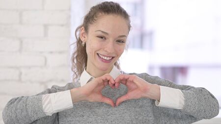 Portrait of Young Latin Woman making Heart Shapeの写真素材