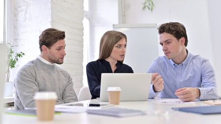 Cheerful Creative Woman doing Video Chat on Laptop in Office