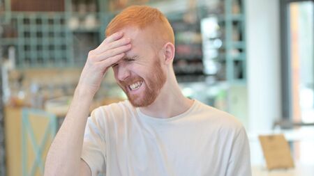 Portrait of Stressful Redhead Man having Headache