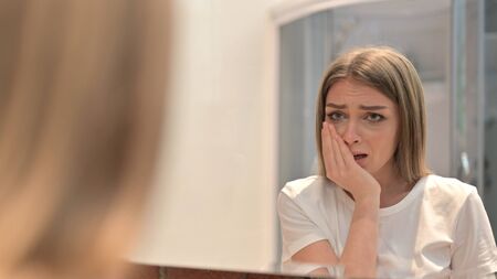 Rear View of Upset Young Woman Crying in the Mirrorの写真素材
