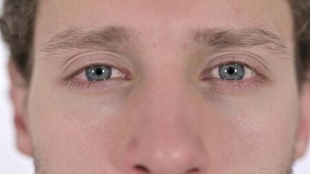 Close up of Blinking Eyes of Young Man on White Backgroundの写真素材
