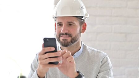 Young Engineer Browsing Internet on Smartphoneの写真素材