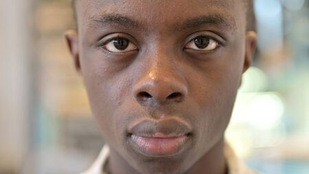 Close up of Serious Young African Man Looking at Cameraの写真素材