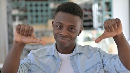 Portrait of Disappointed Young African Man doing Thumbs Downの写真素材