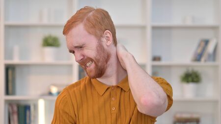 Portrait of Tired Redhead Man having Neck Painの写真素材