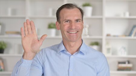 Portrait of Middle Aged Businessman Waving Handの写真素材