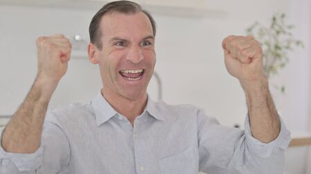 Portrait of Cheerful Middle Aged Man Celebrating Success