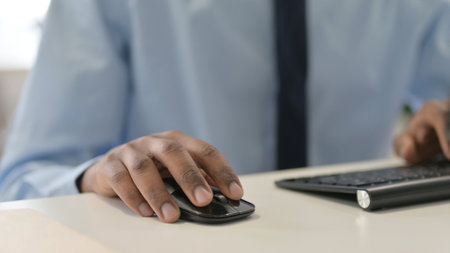 Hands of African Man Using Mouse and Keyboard, Close Up