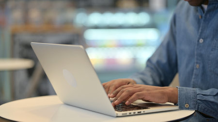 African Man Typing on Laptop Keyboard, Close Upの写真素材