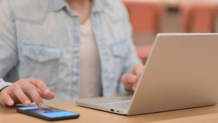 Male Hands using Smartphone and Typing on Laptop, Close up
