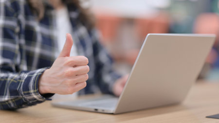 Female Hands showing Thumbs up while using Laptop, Close upの写真素材