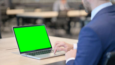 Businessman Working on Laptop with Green Chroma Screenの写真素材