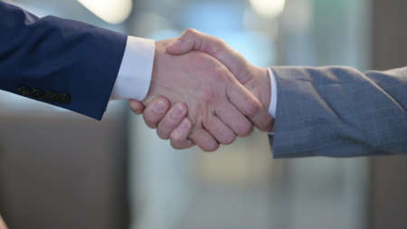 Hand Shake by Two Businessmen at Workの写真素材