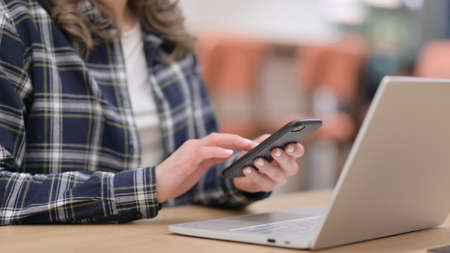 Female with Laptop using Smartphone, Close up