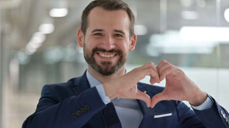 Portrait of Happy Middle Aged Businessman showing Heart Sign with Hand