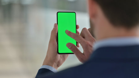 Middle Aged Businessman using Smartphone with Chroma Screenの写真素材