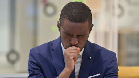 Portrait of Sick African Businessman Coughingの写真素材