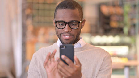 Portrait of Attractive African Man using Smartphoneの写真素材