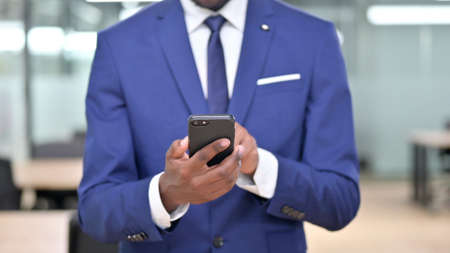 African Businessman Using Smartphone at Workの写真素材
