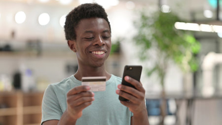 Online Shopping by Young African Man, Online Payment on Smartphoneの写真素材