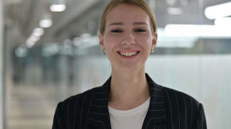 Smiling Young Businesswoman Looking at Camera