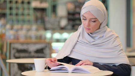 Studious Young Arab Woman Reading Bookの写真素材