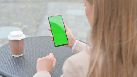Businesswoman Holding Smartphone with Green Chroma Screen Outdoorの写真素材
