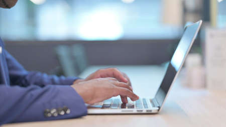 Hands Close up of Young African Businessman Typing on Laptop