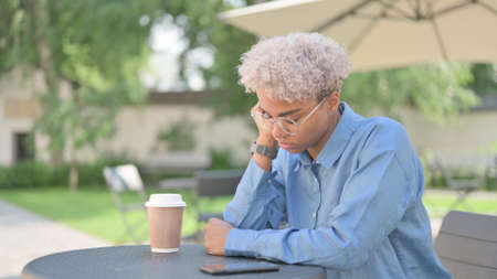 African Woman Taking Nap in Outdoor Cafe