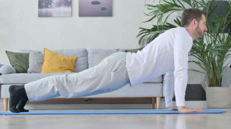 Side View of Mature Adult Man doing Push Ups at Home