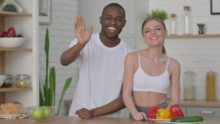 Woman and African Man Talking on Video Call in Kitchenの写真素材