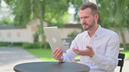 Mature Adult Man Upset by Loss on Tablet