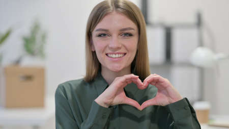 Young Woman making Heart Sign by Handの写真素材