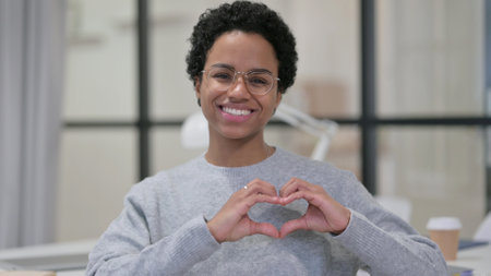 African Woman making Heart Shape by Handsの写真素材