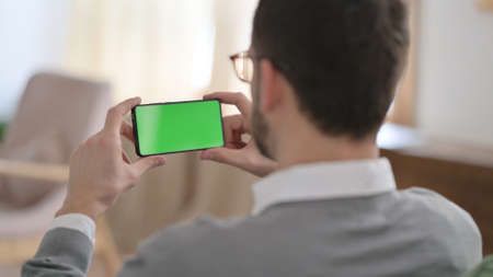 Rear View of Man Watching Smartphone with Chroma Key Screen