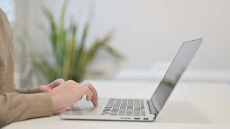 Close Up of Man Using Laptop for Workの写真素材